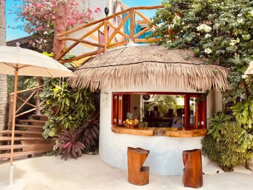 a small house with a thatched roof and a restaurant at Hotel Para Ti - Adults Only in Holbox Island