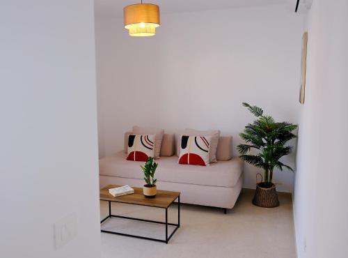 a living room with a white couch with pillows and a table at La Maltese Central in Naousa