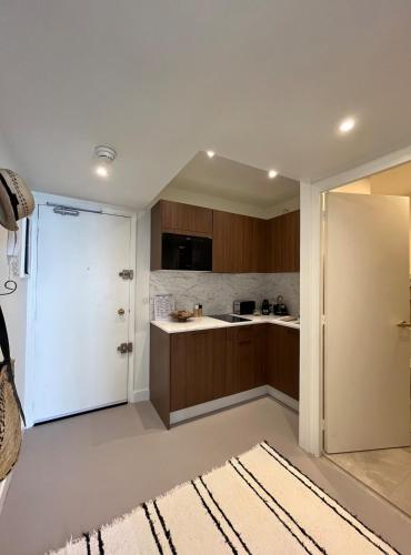 une cuisine avec des placards bruns et une porte blanche. dans l'établissement Studio Résidence Régina et golf vue mer, à Biarritz