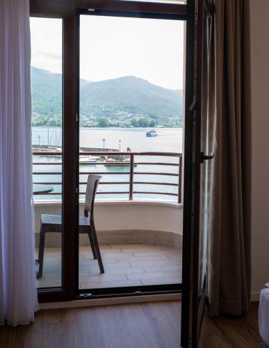 a room with a balcony with a chair and a window at Hotel Aleksandrija in Ohrid