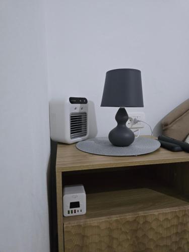 a table with a lamp and a radio on it at Klaudija in Igalo