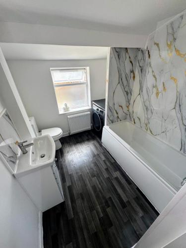 a bathroom with a toilet and a sink and a tub at Comfortable Room in Redfield - Easy City Access in Bristol