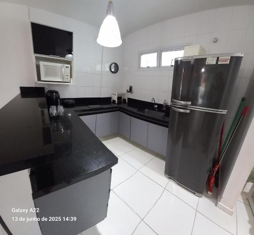 a kitchen with a stainless steel refrigerator and a sink at MANDAI Apartamento Cabo Frio in Cabo Frio