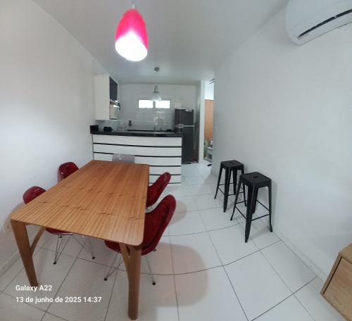 a kitchen and dining room with a wooden table and chairs at MANDAI Apartamento Cabo Frio in Cabo Frio