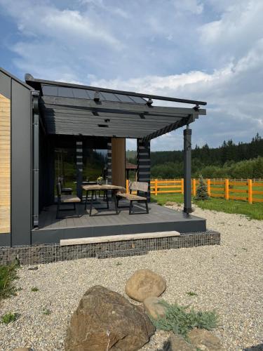 a pavilion with a picnic table and a bench at The Prut Lodge in Vorokhta
