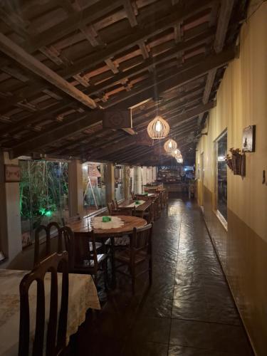 a dining room with tables and chairs in a restaurant at Mundial Chalés e Ecoturismo in Delfinópolis
