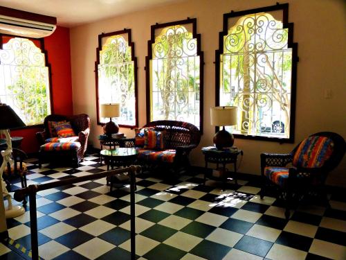 a living room with couches and chairs and windows at Canario Boutique Hotel in San Juan