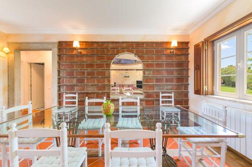 a room with chairs and a brick wall at Quinta das Tílias in Santiago do Cacém
