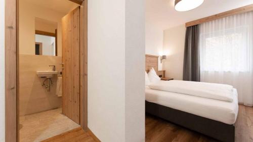 a hotel room with a bed and a bathroom at Gasthof Brückenwirt Hotel in Sölden