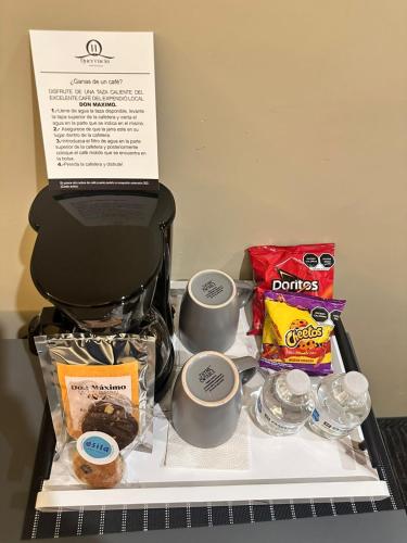 a tray with cups of coffee and some food at Hotel Boutique Querencia in Tijuana