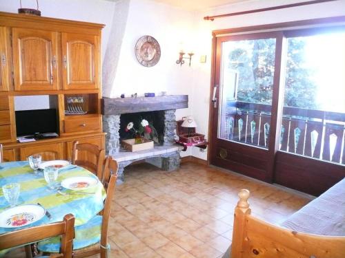 une salle à manger avec une table et une cheminée dans l'établissement Résidence Les Terrasses Du Mont Blanc - 2 Pièces pour 6 Personnes 17, à Combloux
