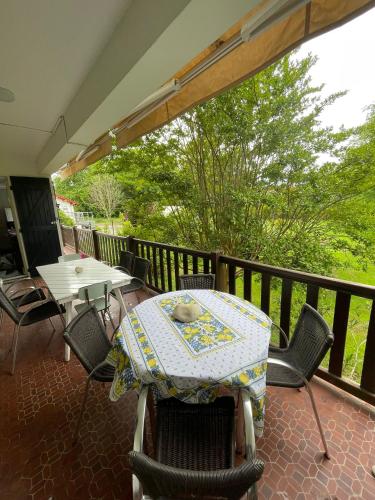 un patio avec une table et des chaises sur un balcon dans l'établissement Maison familiale au calme, à Saint-Pée-sur-Nivelle