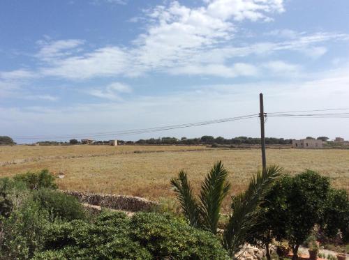 a field with a telephone pole in the middle of a field at Favignana Vacanze in Favignana