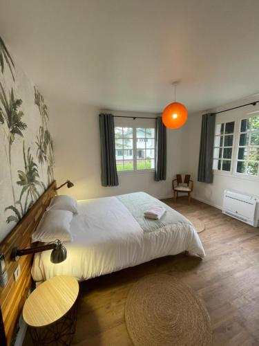 une chambre avec un grand lit et une lumière orange dans l'établissement Maison familiale au calme, à Saint-Pée-sur-Nivelle