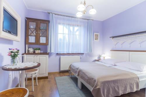 カジミエシュ・ドルニにあるDom Góreckichのベッドルーム1室(ベッド2台、テーブル、テレビ付)