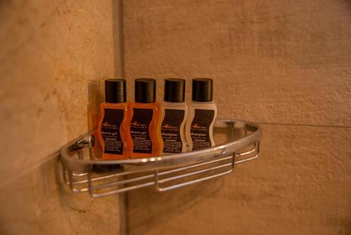 a group of four toothbrushes on a rack in a bathroom at Hotel Aleksandrija in Ohrid