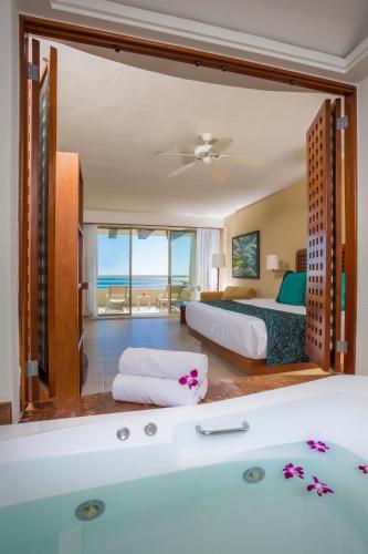 a bedroom with a tub and a bed with a view at GR Solaris Lighthouse - All Inclusive in San José del Cabo