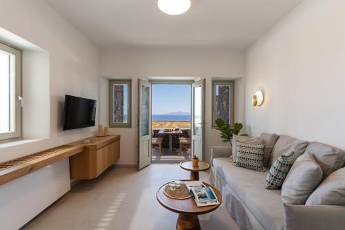 a living room with a couch and a television at Platies Luxury Apartments Santorini in Éxo Goniá