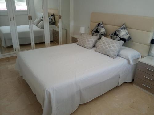 a bedroom with a large white bed with mirrors at ELIO Murcia El Carmen in Murcia