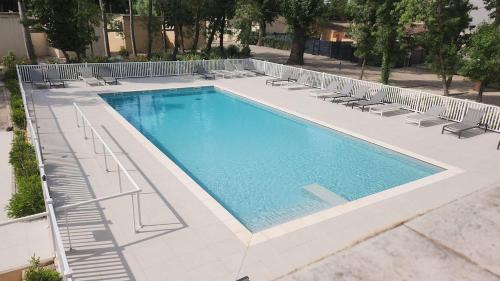 - une piscine entourée de chaises longues dans l'établissement Appartement 3 Chambres, terrasse privée, piscine, parking, à Saint-Rémy-de-Provence