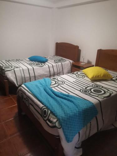 two beds sitting next to each other in a room at Casa mãe in Lajes do Pico
