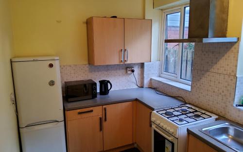 a kitchen with a white refrigerator and a sink at Sure stay property in Bolton