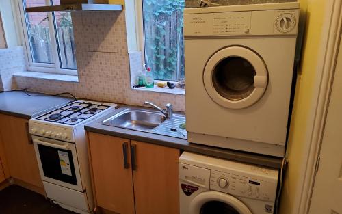 a kitchen with a sink and a washing machine at Sure stay property in Bolton