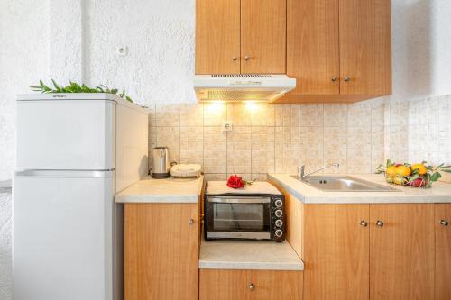 a small kitchen with a microwave and a sink at Averto in Benitses
