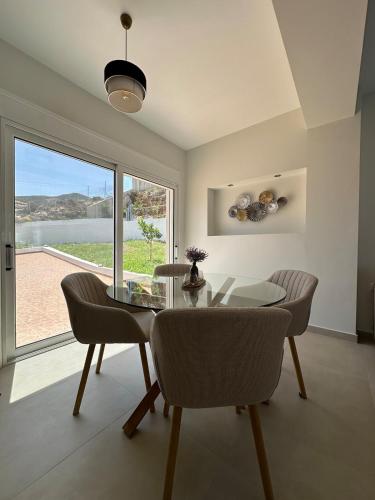 a dining room with a glass table and chairs at Villa Yimaré mit privatem Pool und Meerblick in Gázion
