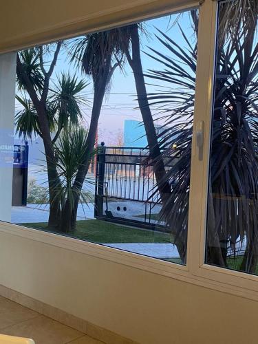 a window with a view of the ocean and palm trees at Jardín del Mar in Playa Unión