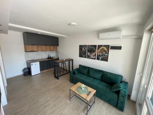 a living room with a green couch and a kitchen at Dora 2 in Veliko Gradište