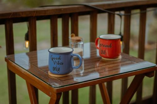 two coffee mugs sitting on a wooden table at La Cabaña Alpina de Huimilpan in Pedro Escobedo