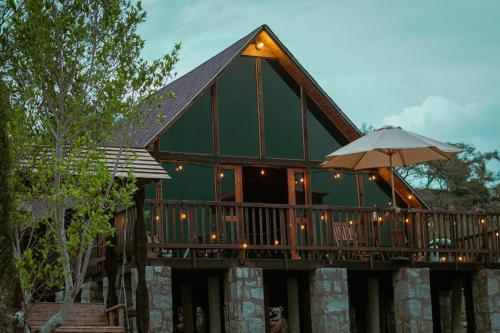 a house with a large deck with an umbrella at La Cabaña Alpina de Huimilpan in Pedro Escobedo