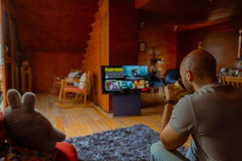 a man sitting in a living room eating food at La Cabaña Alpina de Huimilpan in Pedro Escobedo