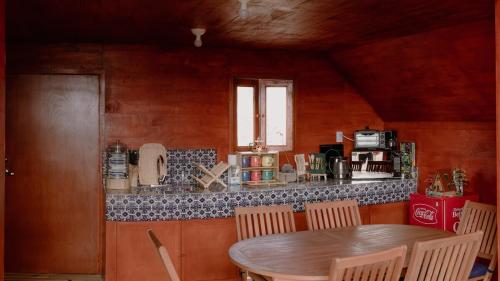 a table and chairs in a kitchen with a counter at La Cabaña Alpina de Huimilpan in Pedro Escobedo