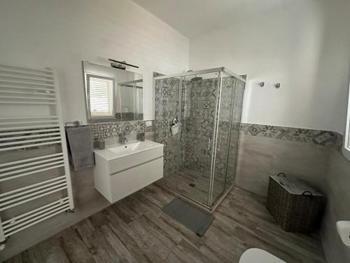 a bathroom with a shower and a sink and a mirror at Tenuta Sillo - ground floor in Uggiano Montefusco