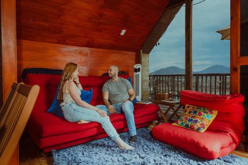 a man and a woman sitting on a red couch at La Cabaña Alpina de Huimilpan in Pedro Escobedo