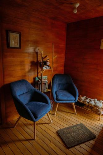 two blue chairs in a room with wooden walls at La Cabaña Alpina de Huimilpan in Pedro Escobedo