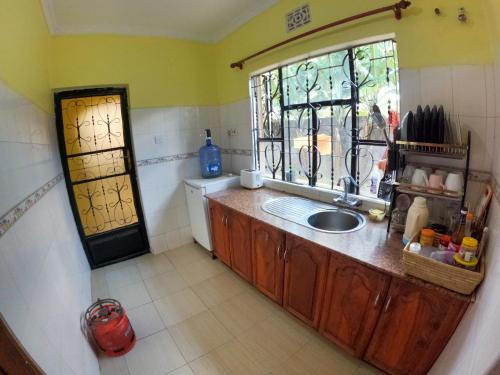 a kitchen with a sink and a window at Sofa So Good Backpackers' Nest in Arusha