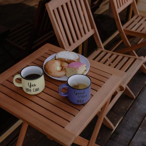 a table with two cups of coffee and a plate of donuts at La Cabaña Alpina de Huimilpan in Pedro Escobedo