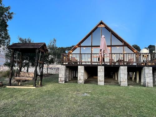 a large wooden house with a deck and a bench at La Cabaña Alpina de Huimilpan in Pedro Escobedo