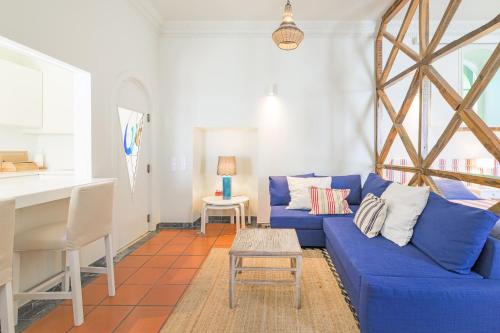 a living room with a blue couch and a table at Império House in Santiago do Cacém