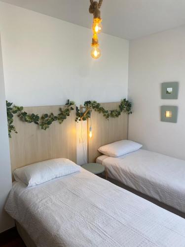 two beds in a room with white walls at V&B VACACIONAL in Suances