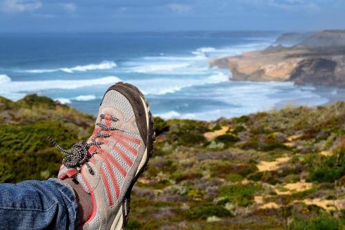 a person standing on top of a mountain with their shoe at Onda Vicentina Guesthouse in Aljezur