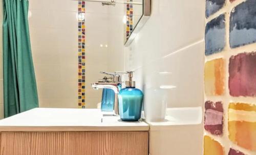 a bathroom with a sink with a blue bottle on it at Onda Vicentina Guesthouse in Aljezur