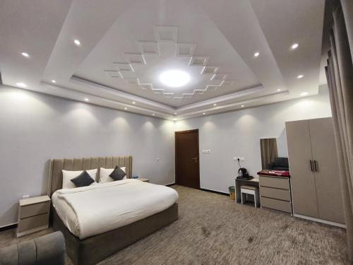 a hotel room with a bed and a television at Al Rayhan Suites الريحان للأجنحة المفروشة in Al Madinah