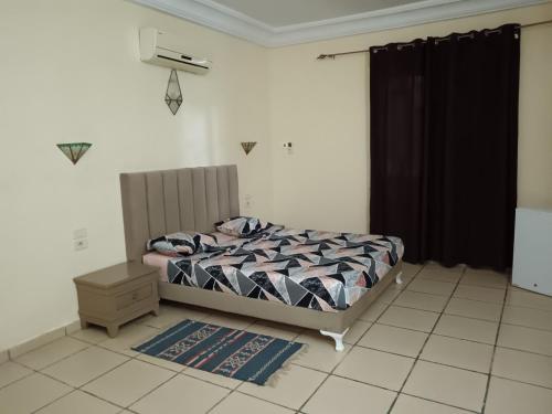 a bedroom with a bed and a black curtain at Résidence Loued in Tozeur