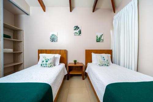 two beds in a small room with green and white at Villa Serenidad Costera in Sardinal