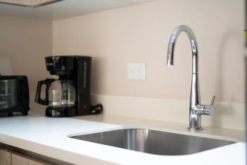 a kitchen counter with a sink and a coffee maker at Villa Serenidad Costera in Sardinal