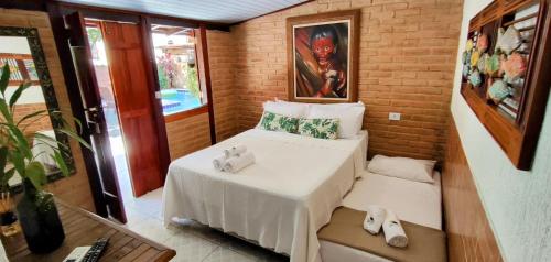 a small room with two beds in a room at Portal Suítes Casa do Lago in Paraty